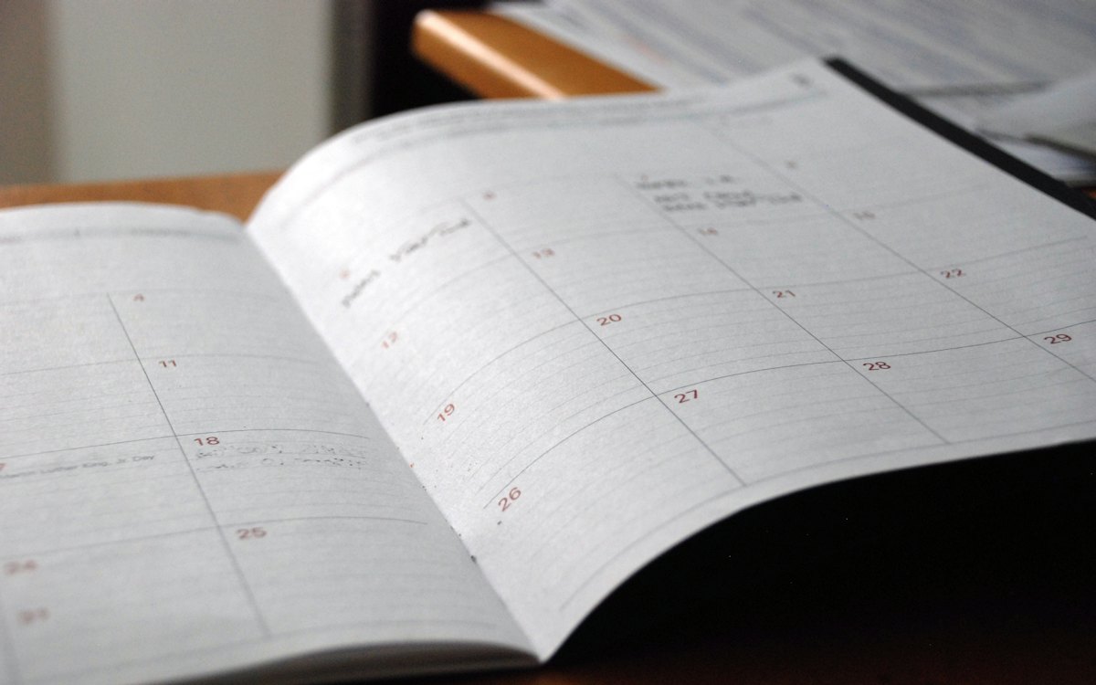 Agenda aberta com páginas de calendário sobre a mesa
