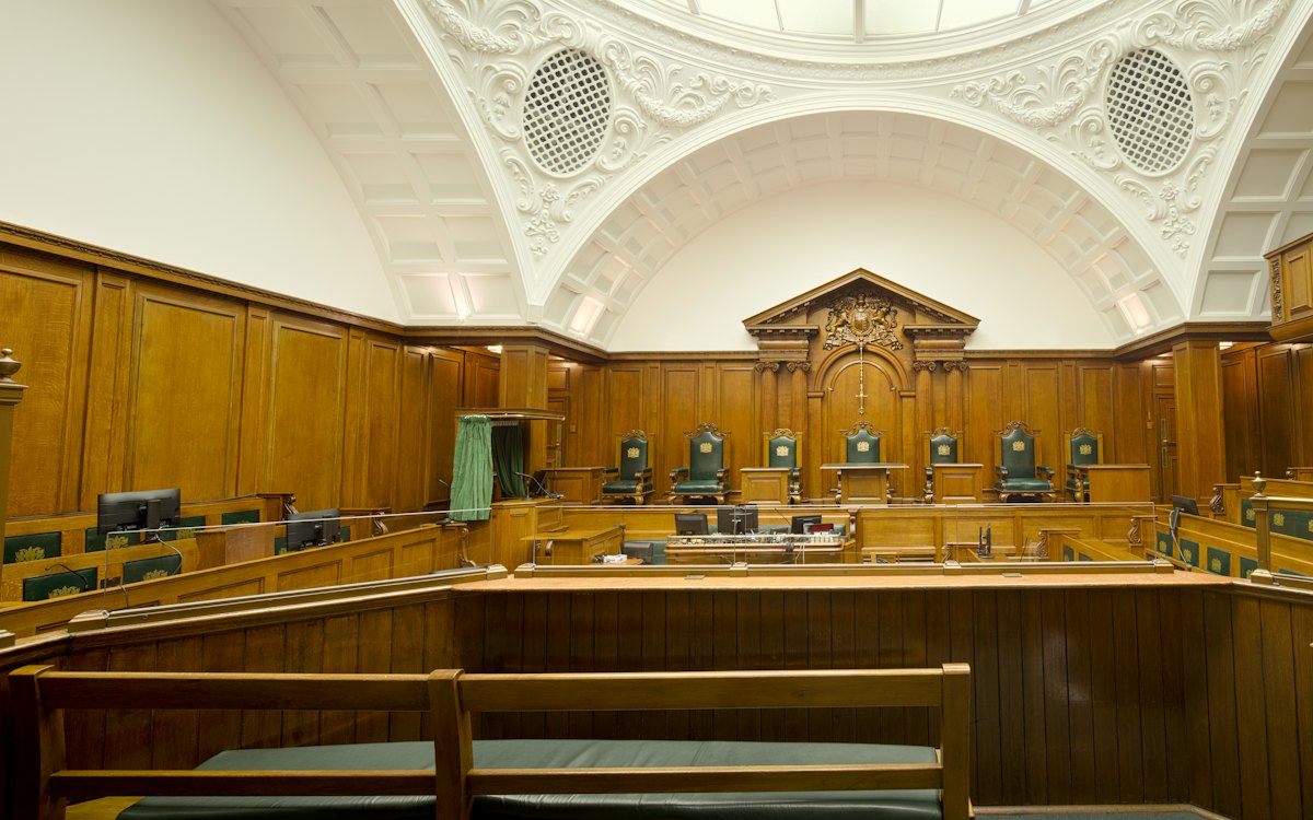 Sala de audiências com bancos e bancadas de madeira