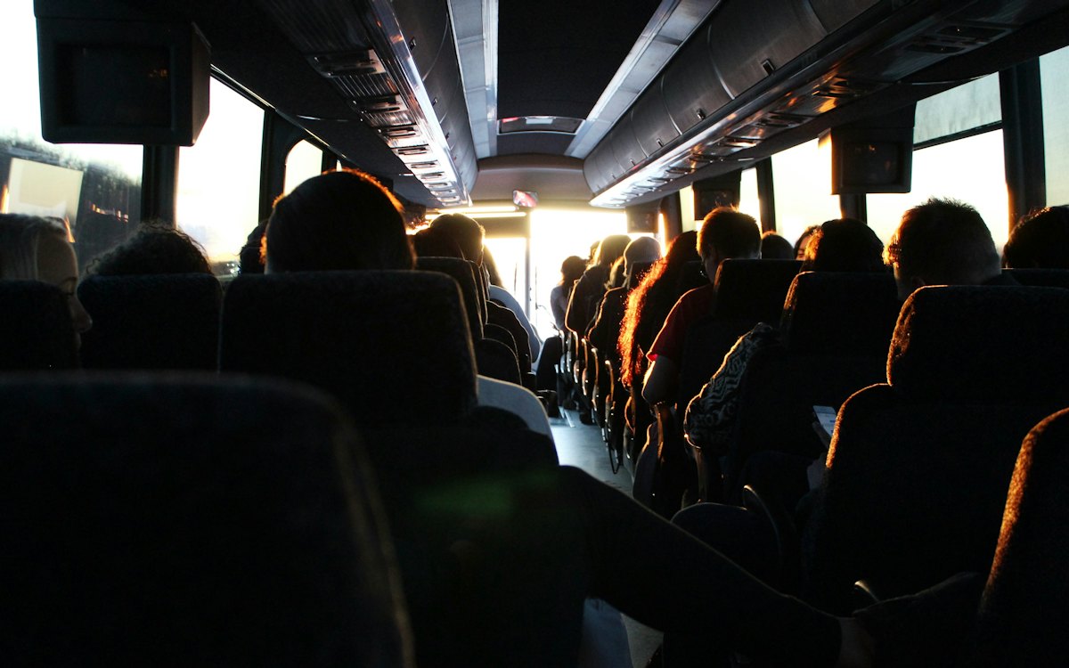 Passageiros sentados dentro de um ônibus