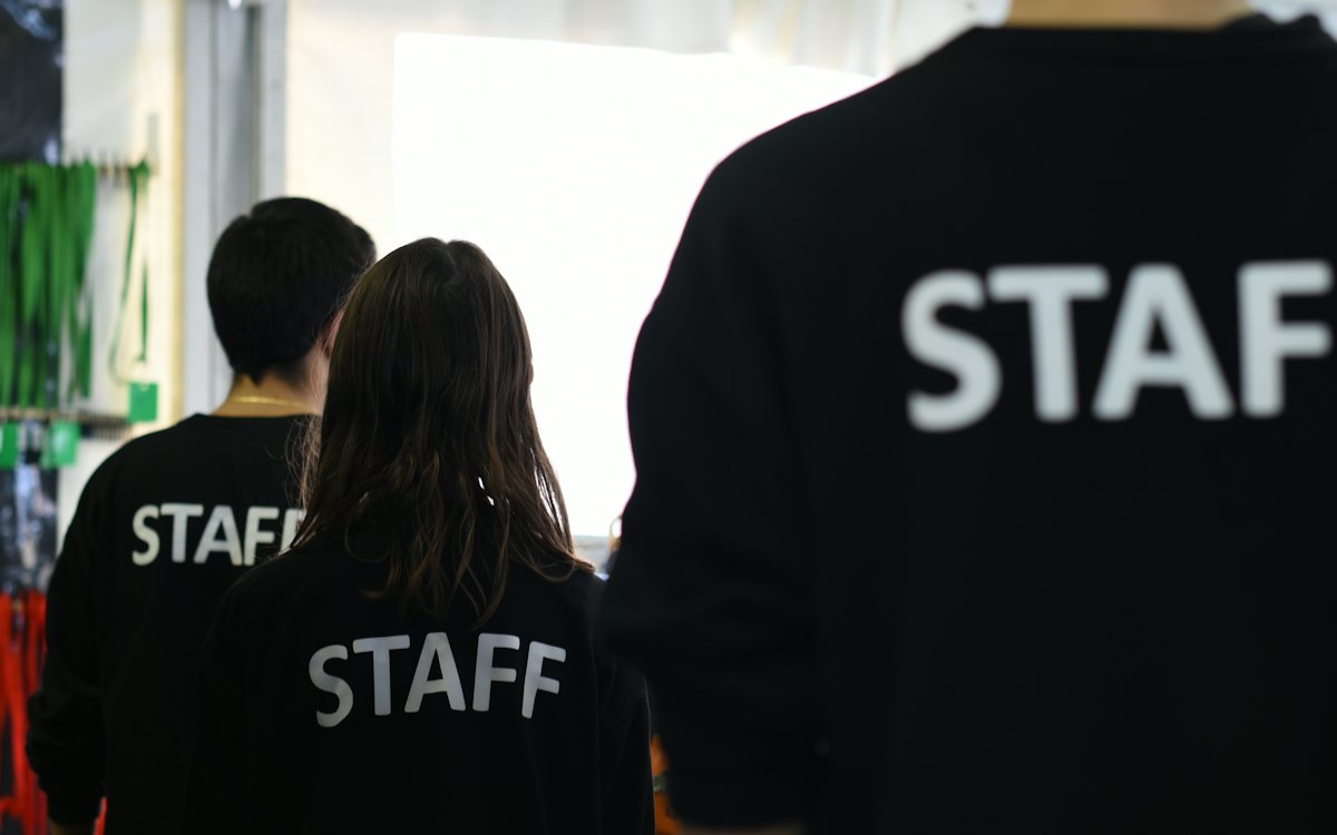 Trabalhadores de costas com camisetas de equipe