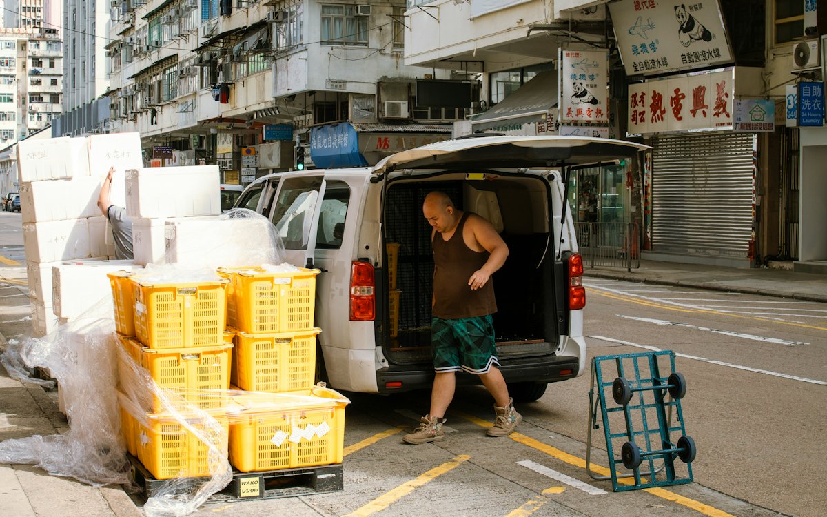 Entregador descarregando mercadorias de uma van na rua