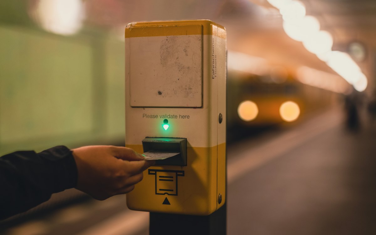 Mão aproximando o cartão do validador de transporte público